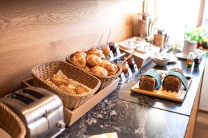 - un buffet composé de pain et de viennoiseries sur un comptoir dans l'établissement Gasthof zur Post, à Maishofen