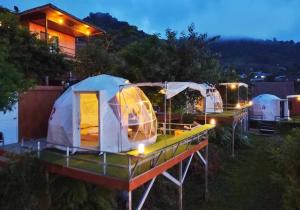 Mon Jam的住宿－Phu Fahsai Homestay，一群帐篷在晚上停在院子里