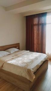 - un grand lit dans une chambre avec fenêtre dans l'établissement Tikas'home, à Tbilissi