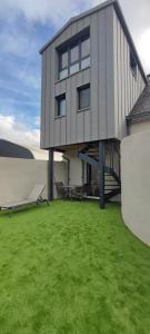 a building with a grassy yard in front of it at Gîte de Bonneville in Nantes