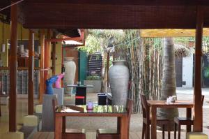 a restaurant with tables and chairs and a large vase at Dickman Resort "The Boutique Hotel" in Negombo