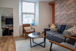 a living room with a couch and a table at City Chic Apartment in Newport