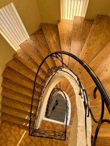 a spiral staircase in a room with a wooden ceiling at Happy House in Kutaisi