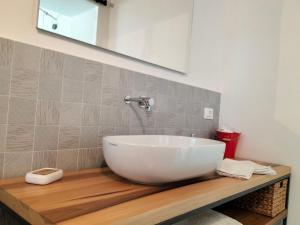 a white bowl sink on a wooden counter in a bathroom at Casa Giufà B&B in Chiaramonte Gulfi