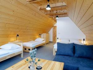 a room with two beds and a couch and a table at Villa Taternik by Golden Apartments in Zakopane
