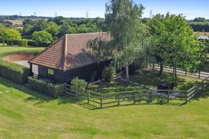 an overhead view of a house with a tree and a fence at The Stables Rectory Farm in Halstead