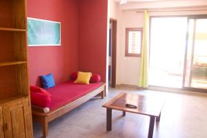 ein Wohnzimmer mit einem Sofa und einem Tisch in der Unterkunft Hôtel Résidence Sarimanok in Ambatoloaka