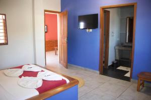 sypialnia z łóżkiem i niebieską ścianą w obiekcie Hôtel Résidence Sarimanok w mieście Ambatoloaka
