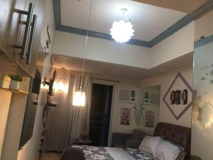 a room with a bed and a chandelier at Condo for rent -The Loop Residences-relaxing , unique and satisfying in Cagayan de Oro