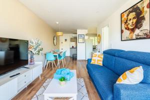 a living room with a blue couch and a table at Cassis - Le Capucine, 4pers, terrasse, classé 3 étoiles in Cassis