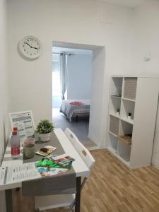 una habitación con una mesa y un reloj en la pared en Apartamentos La Campana 1, en Jerez de la Frontera