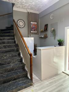 a staircase in a house with a clock on the wall at Kaynarca Butik Hotel in İznik