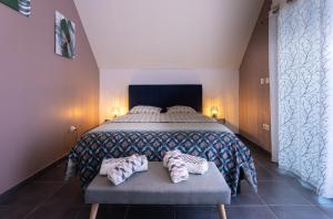 ein Schlafzimmer mit einem Bett und zwei Handtüchern auf einer Bank in der Unterkunft Leu Corail in Saint-Leu