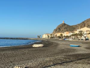 a beach with two boats sitting on the shore at Apartamento La Mamola in La Mamola