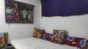 a room with paintings on the wall and a bed at Dede Sebo Çay Bahçesi + Camping in Doğubayazıt