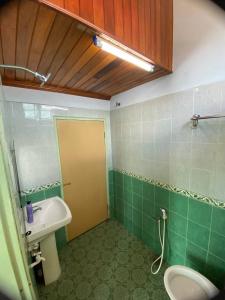 La salle de bains verte est pourvue d'un lavabo et de toilettes. dans l'établissement Sri Panorama Home, à Kota Bharu