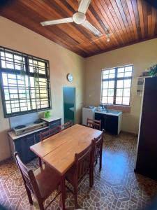 - une salle à manger avec une table et des chaises en bois dans l'établissement Sri Panorama Home, à Kota Bharu
