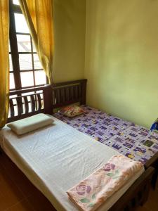 - un petit lit dans une chambre avec fenêtre dans l'établissement Sri Panorama Home, à Kota Bharu