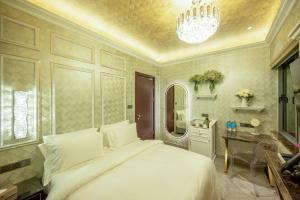a bedroom with a large white bed and a chandelier at Ritz Residence @ Imago Loft B 7th Floor in Kota Kinabalu