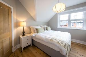 um quarto com uma cama com um candeeiro e uma janela em South Downs Garden Cottage em Old Town