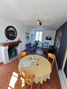 salon ze stołem, krzesłami i kominkiem w obiekcie La Jacquière w mieście Chaumont-sur-Loire