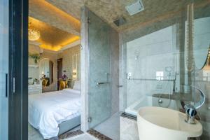 a bathroom with a shower and a tub and a bed at Ritz Residence @ Imago Loft B 7th Floor in Kota Kinabalu