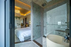 Ritz Residence @ Imago Loft B 7th Floor في كوتا كينابالو: حمام مع دش وسرير وحوض استحمام