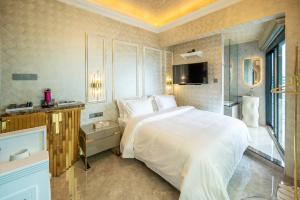 a bedroom with a large white bed and a bathroom at Ritz Residence @ Imago Loft B 7th Floor in Kota Kinabalu