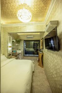 a bedroom with a large white bed and a chandelier at Ritz Residence @ Imago Loft B 7th Floor in Kota Kinabalu