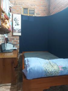 - une chambre avec un mur bleu, un bureau et un lit dans l'établissement Handmade Store Măng Đen, à Kon Von Kla