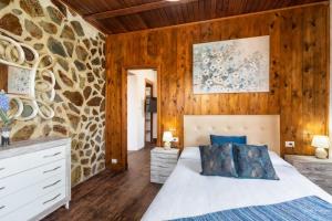 1 dormitorio con cama y pared de piedra en LAS VALKIRIAS, en El Paso