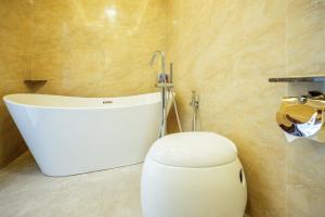 a bathroom with a toilet and a bath tub at Ritz Residence @ Imago Loft B 7th Floor in Kota Kinabalu