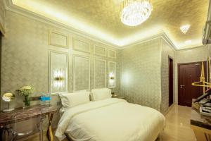 a bedroom with a large white bed and a chandelier at Ritz Residence @ Imago Loft B 7th Floor in Kota Kinabalu
