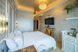 a bedroom with a white bed and a tv at Ritz Residence @ Imago Loft B 7th Floor in Kota Kinabalu