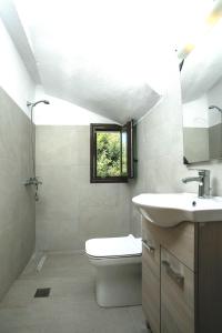 uma casa de banho com um WC, um lavatório e uma janela em Emarmene Sea View & Mountain Hideaway near Faliraki and Airport em Afantou