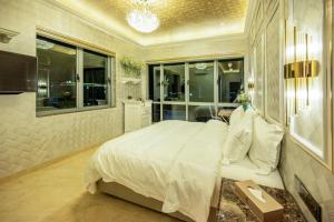 a bedroom with a large white bed and a bathroom at Ritz Residence @ Imago Loft B 7th Floor in Kota Kinabalu