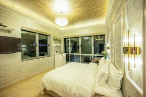 a bedroom with a large white bed and windows at Ritz Residence @ Imago Loft B 7th Floor in Kota Kinabalu