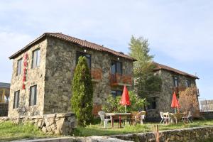 a stone house with tables and umbrellas in front of it at ArtStar in Sevan