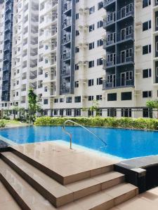 a swimming pool in front of some apartment buildings at 1 Br CONDO Vine Residences Quezon City with POOL NETFLIX WIFI VIDEOKE BOARD GAMES in Manila
