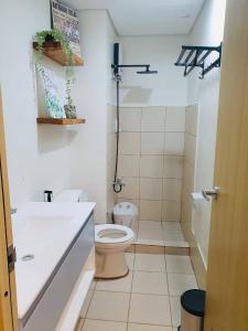 La salle de bains blanche est pourvue de toilettes et d'un lavabo. dans l'établissement 1 Br CONDO Vine Residences Quezon City with POOL NETFLIX WIFI VIDEOKE BOARD GAMES, à Manille