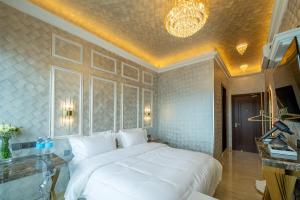 a bedroom with a large white bed and a chandelier at Ritz Residence @ Imago Loft B 7th Floor in Kota Kinabalu