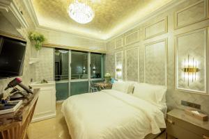 a bedroom with a large white bed and a chandelier at Ritz Residence @ Imago Loft B 7th Floor in Kota Kinabalu