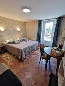 Schlafzimmer mit einem Bett, einem Tisch und einem Fenster in der Unterkunft La Jacquière in Chaumont-sur-Loire