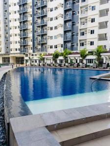 a large swimming pool in front of some buildings at 1 Br CONDO Vine Residences Quezon City with POOL NETFLIX WIFI VIDEOKE BOARD GAMES in Manila