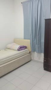 a bed sitting in a room with a curtain at PR1MA Presint 11 Putrajaya in Putrajaya