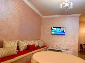 sala de estar con sofá y TV en la pared en Parfaite appartement en résidence en Marrakech