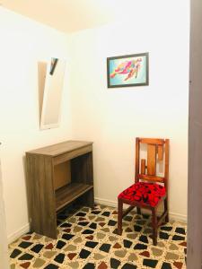 a room with a chair and a table and a mirror at hostal la 18 in Pereira