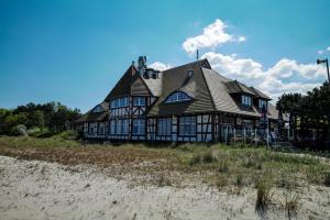 Una casa grande situada encima de una playa. en Ferienwohnung Meerfarbig Zingst - HAUSTIERFREI -Balkon - WLAN - Parkplatz - Fahrradschuppen - zentral&ruhig - E-Ladesäule - Waschtrockner - Nichtraucher, en Zingst