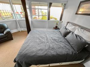 łóżko w pokoju z 2 oknami w obiekcie Whitaker Wish- Spacious, city based apartment with carpark w Auckland