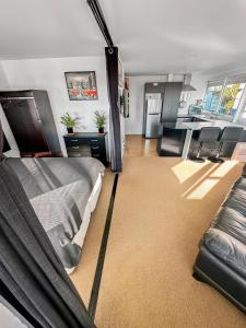 sypialnia z łóżkiem oraz kuchnia z krzesłami w obiekcie Whitaker Wish- Spacious, city based apartment with carpark w Auckland